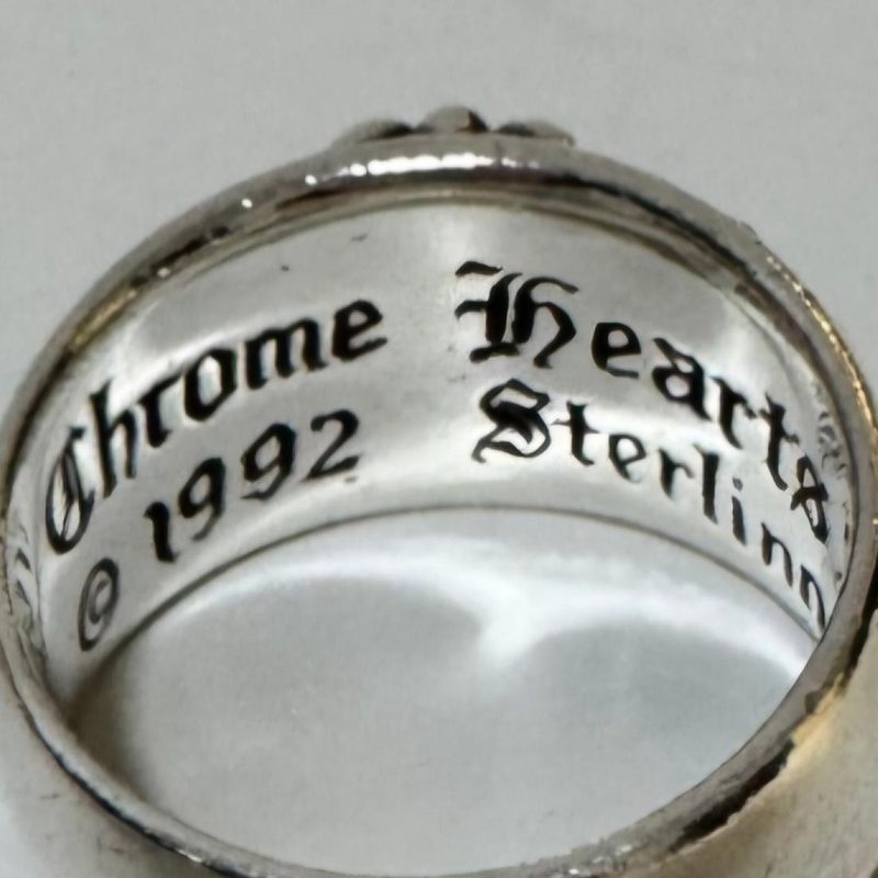 Mặt trong lòng một chiếc nhẫn Chrome Hearts Floral Cross khắc Chrome Hearts, © 1992 và Sterling theo kiểu chữ gothic (blackletter)