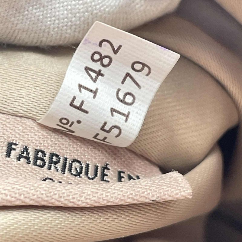 Een stoffen Coach-creedlabel bedrukt met stijl- en fabrieksnummers en zonder datumcode
