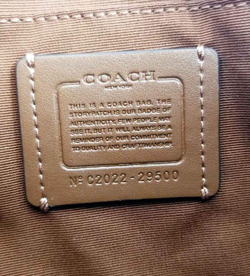 Een leren Coach-creedlabel met zijn nummer geprint onder de tekst