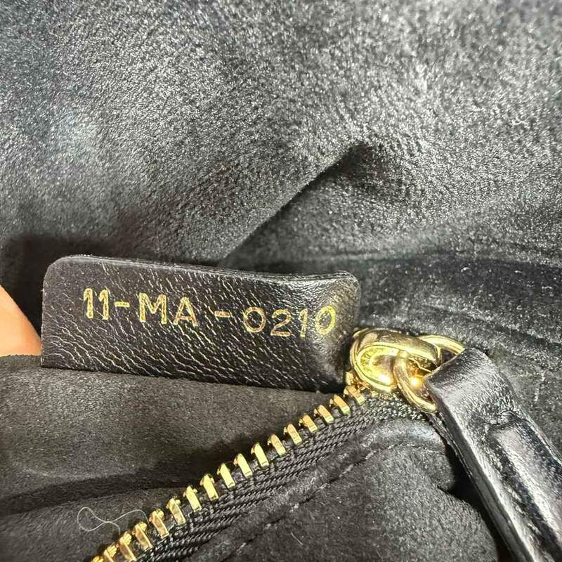 Дата код Dior, вытисненный золотом на обратной стороне черного кожаного внутреннего ярлыка